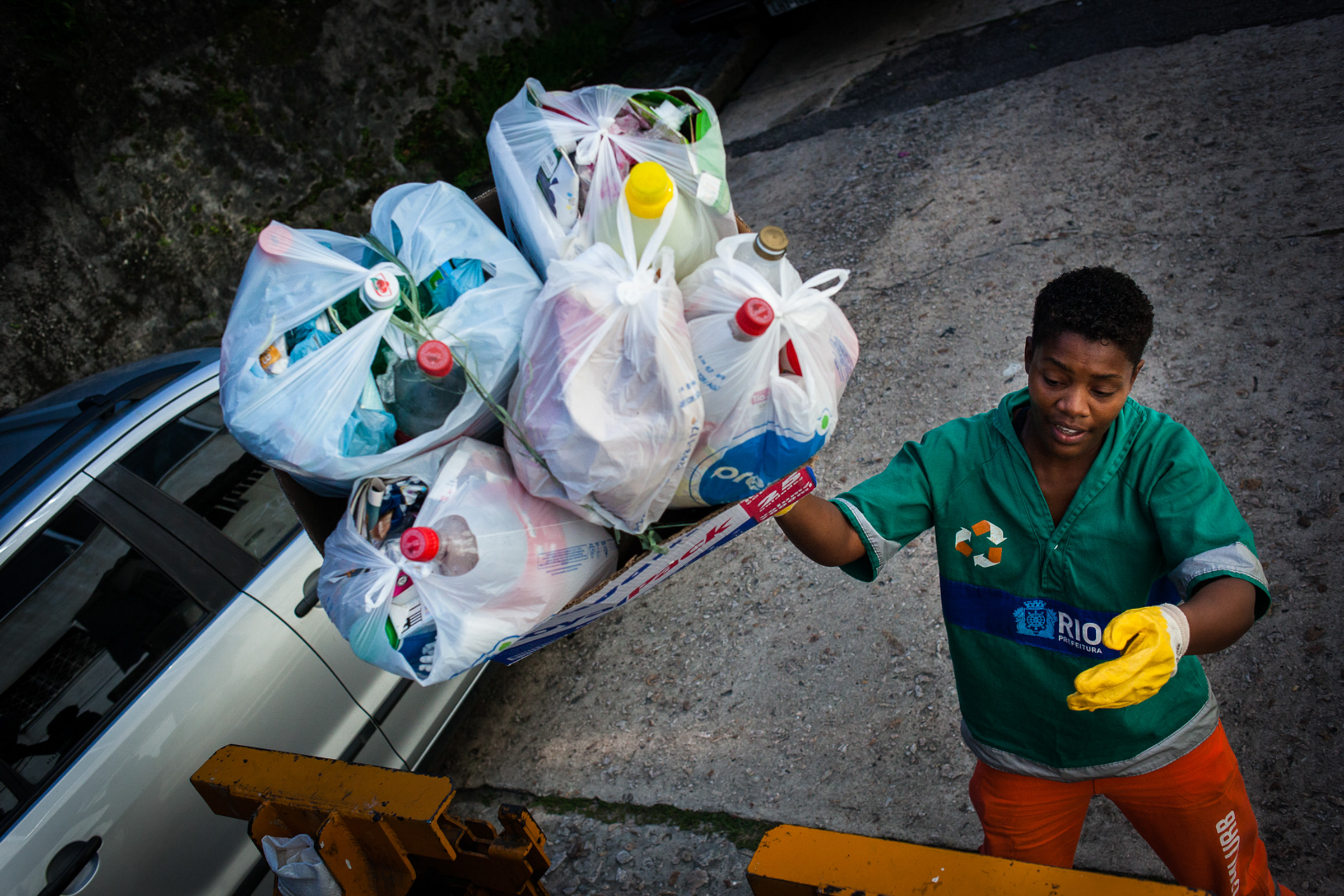 Rio de Janeiro, le 28 Novembre 2013. Collecte sélective sur les hauteurs de Rio. Pas de système automatisé, la collecte se fait à la main, en jetant les sacs dans la benne.

Rio de Janeiro, November 28, 2013. Selective collection on the hills of Rio. No automated system, the collection is handmade, throwing the bags into the dumpster.