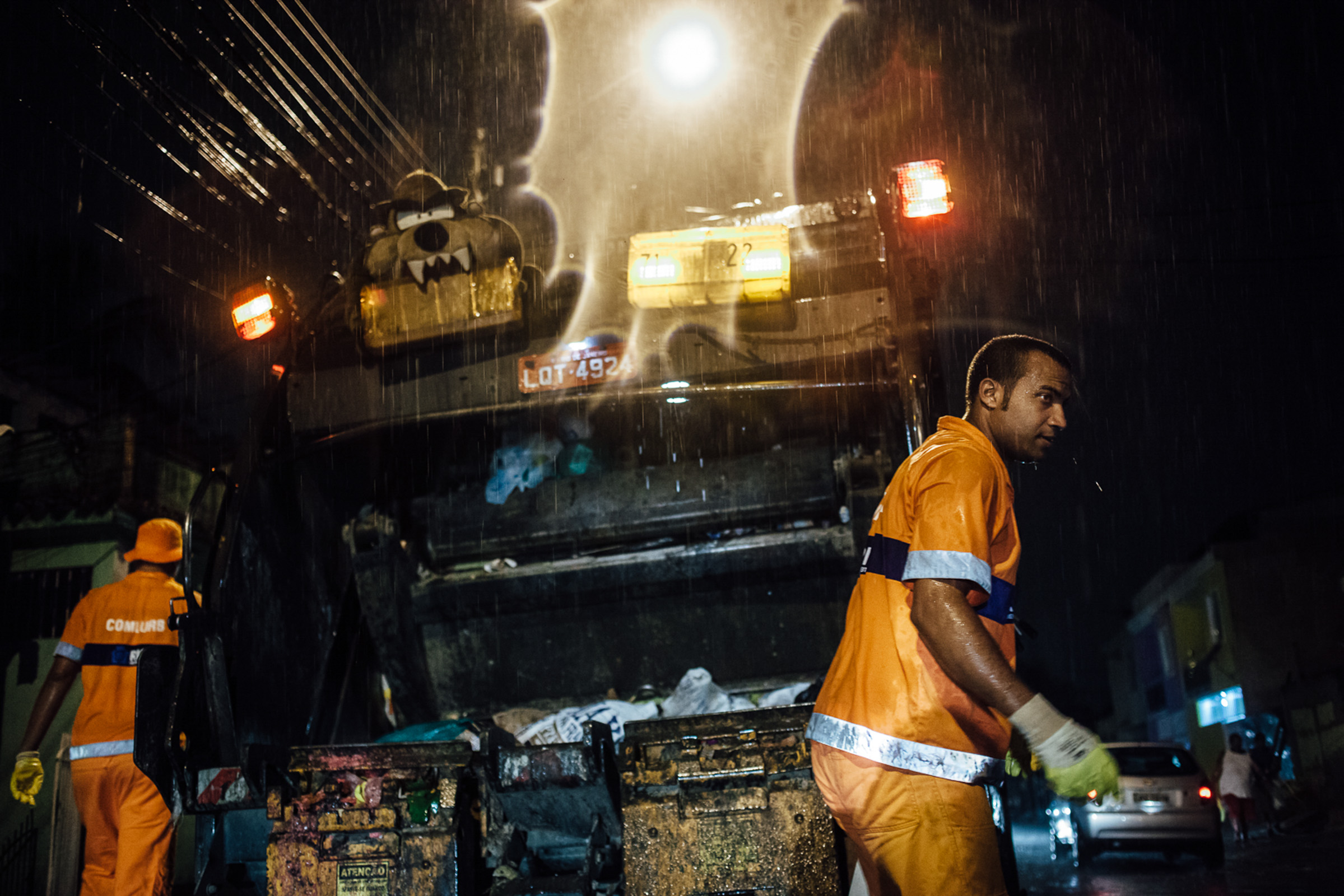 Rio de Janeiro, le 06 décembre 2013. Collecte nocturne dans la zone Ouest de Rio. En passant dans les rues, les garis crient pour demander aux habitants de sortir les poubelles et de les accrocher à leurs portes.

Rio de Janeiro, December 6, 2013. Night gathering in the West Zone of Rio. Passing through the streets, garis (sweepers) shout  asking residents to take out the trash and hang on their doors.