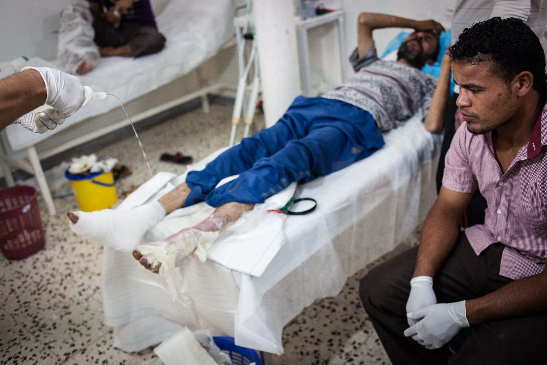 Cheguiga, Juillet 2012. Dans un hôpital mal équipé, les victimes des bombardements de la ville de Cheguiga sont soignées par des infirmiers (pas de médecin sur place). Les membres de la tribu des Machachia sont encore accusés par la brigade de Zenten d'être fidèles au régime de Kadhafi. De leur côté, les Machachia accusent les brigades de Zenten de les bombarder sans raison valable et d'utiliser des armes chimiques (gaz).
Cheguiga, July 2012. In a poorly equipped hospital, victims of bombing in Cheguiga City are cared for by nurses (no doctor on site). Members of the Machachia tribe are still accused by Zenten Brigades to be loyal to the Gaddafi regime. For their part, the Machachia accuse the Zenten brigades to bomb unnecessarily and use of chemical weapons (gas).