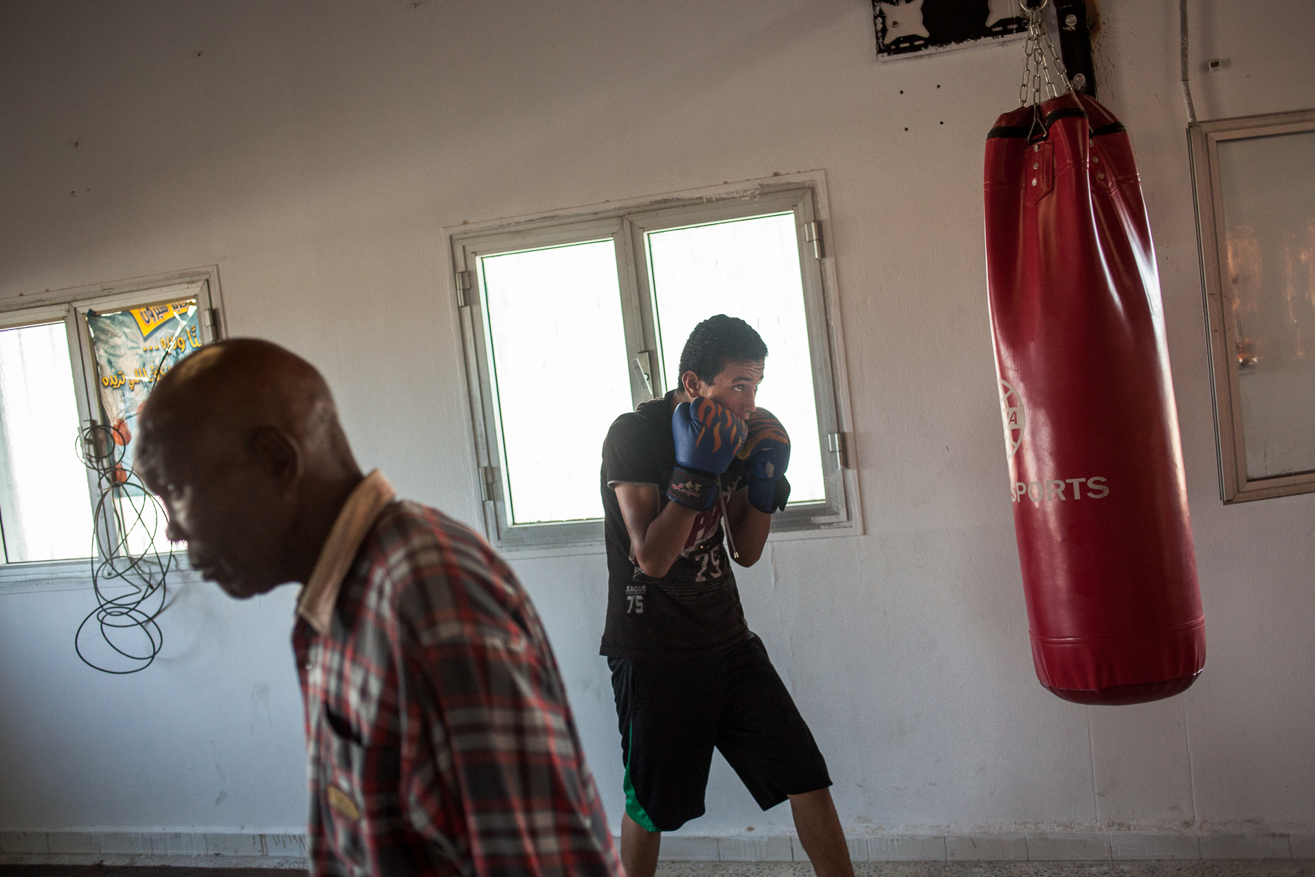 Tripoli, Juillet 2012. Interdite depuis 1979 par Muammar Kadhafi qui trouvait ce sport "sauvage", la boxe revient en Libye. Les jeunes de ce quartier du sud Ouest de Tripoli s'entrainent sous la houlette d'anciens champions.
Tripoli, July 2012. Prohibited since 1979 by Muammar Gaddafi, boxing returns to Libya. Young people of this district in the south west of Tripoli are training under the guidance of former champions.
