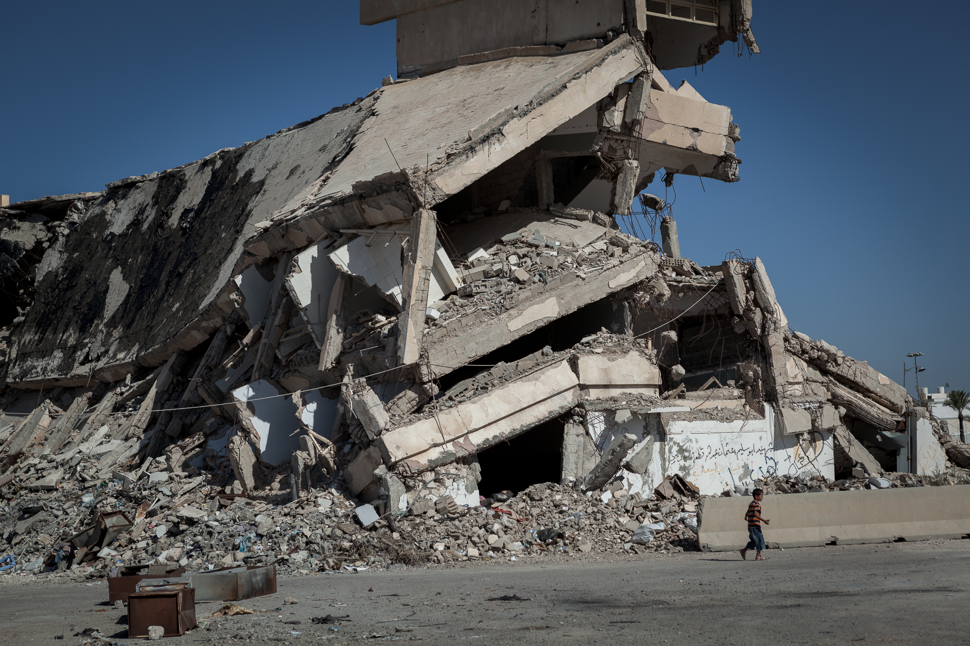 Tripoli, 27 Juin 2012. Bab-al-Azizia, ancien bastion de Kadhafi au centre de Tripoli. Les ruines sont devenues un haut lieu de traffic et de prostitution, ainsi qu'un dépotoire. La majorité des bâtiments ont été détruits par les bombardements de l'OTAN. Après la chute du régime, les habitants de Tripoli ont continué la destruction systématique de ce qui restait debout.
Tripoli, June 27, 2012. Bab al-Azizia, Gaddafi's former stronghold in central Tripoli. The ruins have become a mecca for prostitution and trafficking, as well as a dump. The majority of buildings have been destroyed by NATO bombing. After the fall of the regime, the people of Tripoli continued systematic destruction of what remained standing.