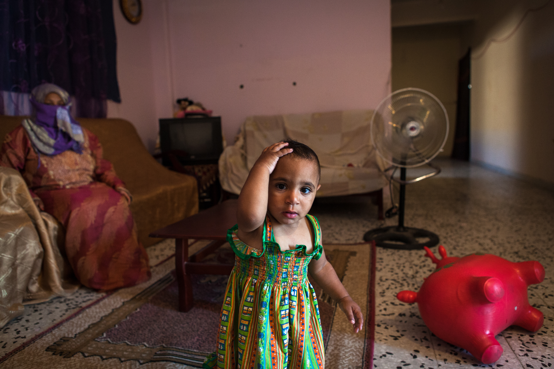 Tripoli, 27 Juin 2012. Bab-al-Azizia, ancien bastion de Kadhafi au centre de Tripoli. Des familles démunies occupent les ruines de la place forte, devenue depuis un haut lieu de traffic (drogues, alcool, prostitution...). Cette femme dont le mari est très souvent absent doit s'occuper seule de sa fille handicapée. Un soir, elle sort de chez elle pour demander aux prostituées d'aller plus loin et d'arrêter le tapin. La nuit même, la façade de leur "appartement" est mitraillé par les milices organisant les trafics dans le complexe. Face aux menaces, elle se dit prête à se battre pour protéger sa famille.
Tripoli, June 27, 2012. Bab al-Azizia, Gaddafi's former stronghold in central Tripoli. Poor families occupy the ruins of the fortress, which has since become a mecca for traffic (drugs, alcohol, prostitution ...). The woman whose husband is often absent, must take care of her disabled daughter alone. One night she came out the door to ask prostitutes to go further and stop the hustler. The same night, the facade of their "apartment" was shot by the militia organizing traffic in the complex. Face of threats, she is willing to fight to protect her family.
