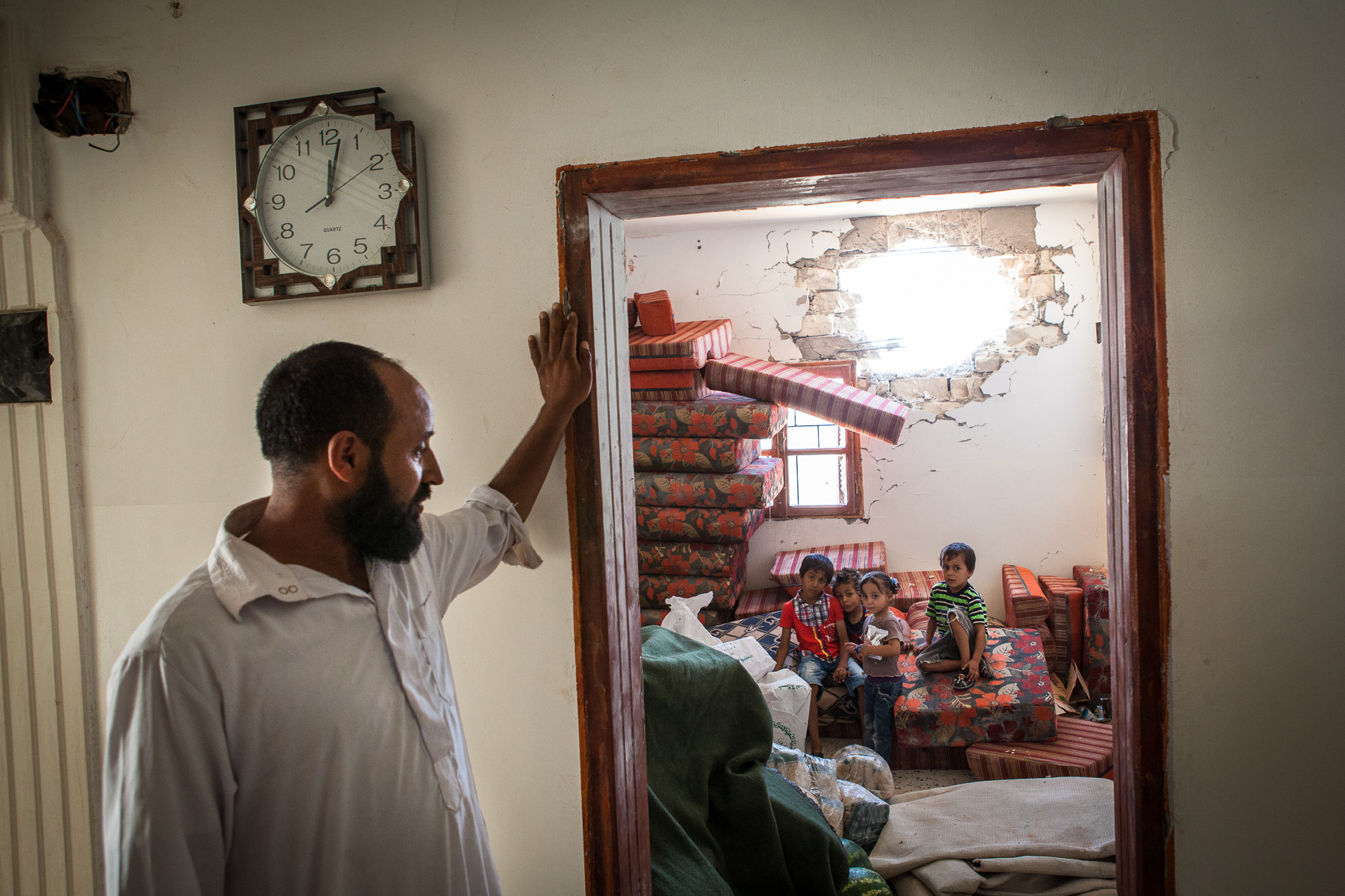 Cheguiga, Juillet 2012. Un père et ses enfants dans les ruines des quartiers civils récemment pilonnés par les brigades de Zenten. Les membres de la tribu des Machachia sont encore accusés par la brigade de Zenten d'être fidèles au régime de Kadhafi.
Cheguiga, July 2012. A father and children in the ruins of civilian neighborhoods recently bombed by Zenten brigades. Members of the Machachia tribes are still accused by Zenten Brigades to be loyal to the Gaddafi regime.