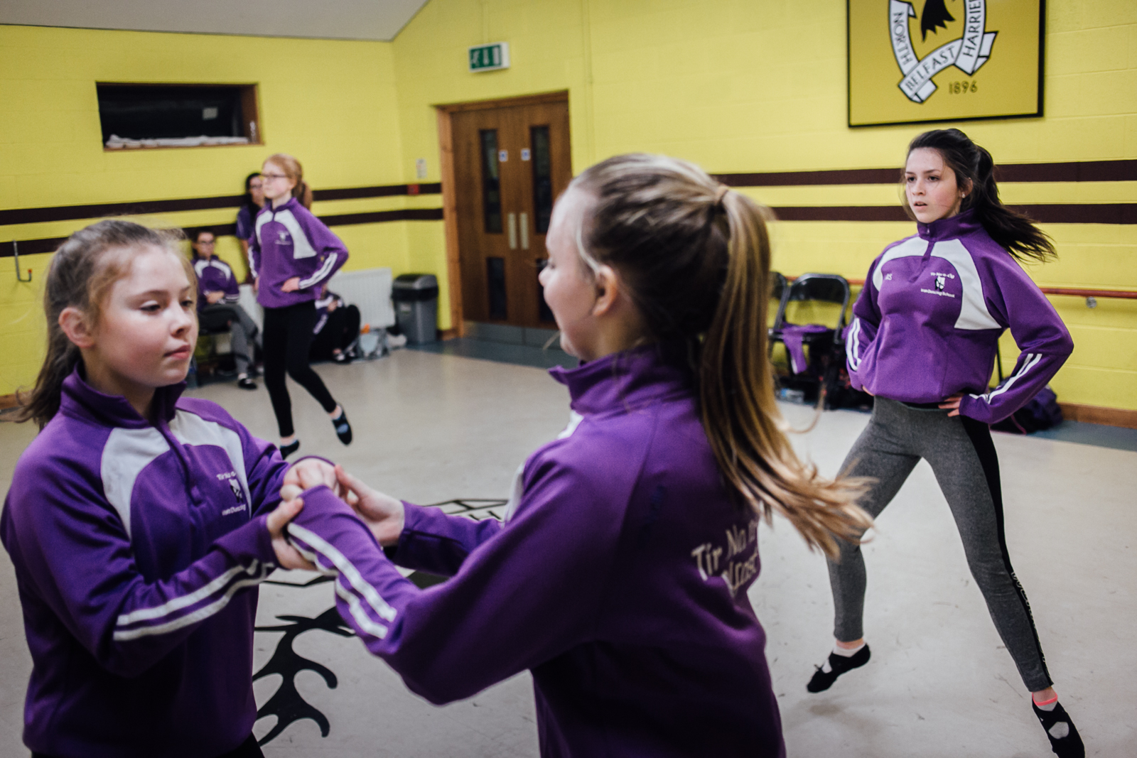 Belfast, le 1er Mars 2017. Une école de danse traditionnelle Irlandaise. Sa particularité est qu'elle est une unitiative de paix. En effet, elle mélange des élèves issues de familles protestantes comme catholiques. Le choix de la couleur (violet) a pour but de choisir une couleur neutre au conflit entre les factions.