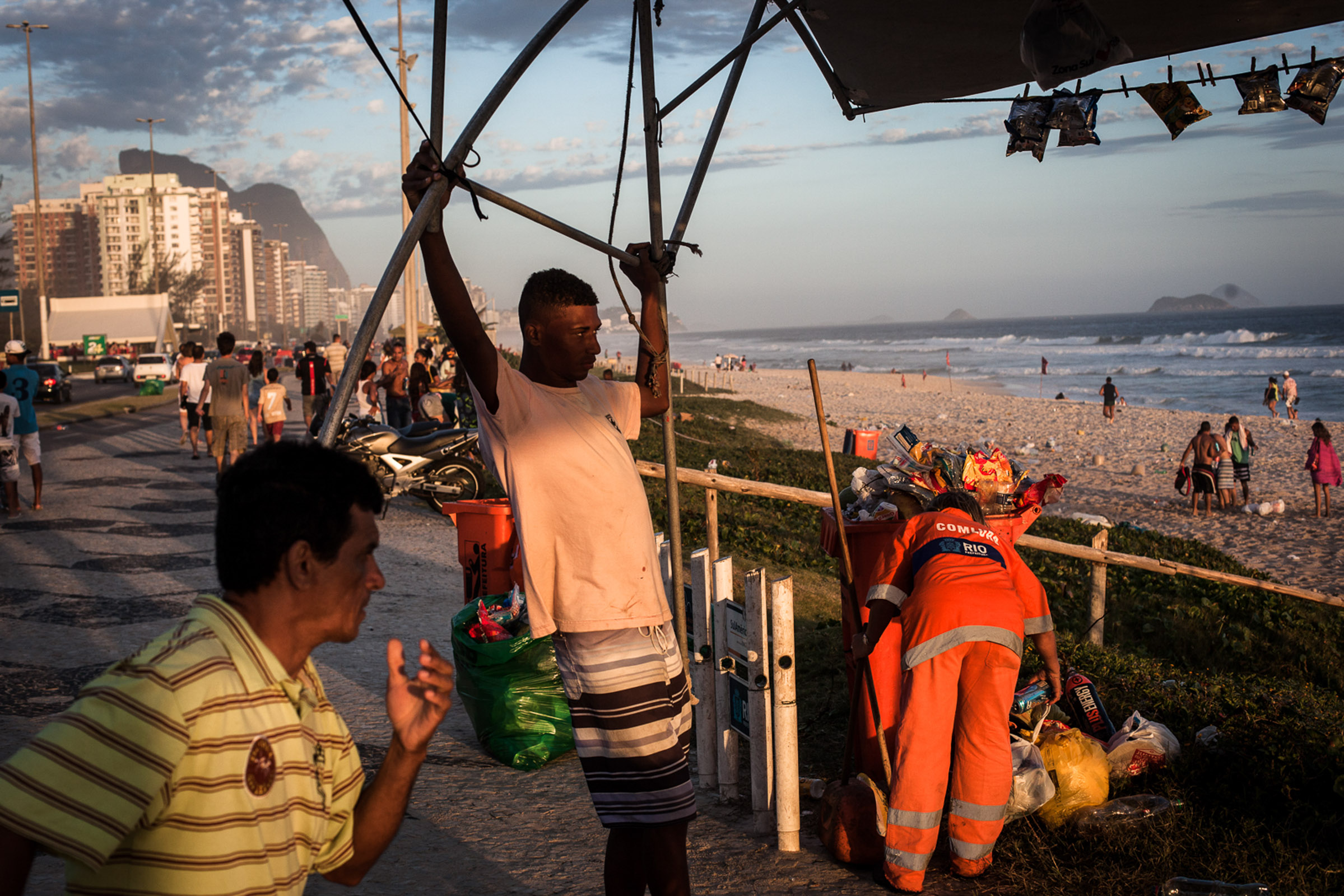 Rio de Janeiro, le 15 Novembre 2013. Fin de journée sur la plage de Barra da Tijuca. Une femme gari commence le nettoyage de la plage.

Rio de Janeiro, November 15, 2013. End of the day on the beach in Barra da Tijuca. A Gari  woman starts cleaning the beach.