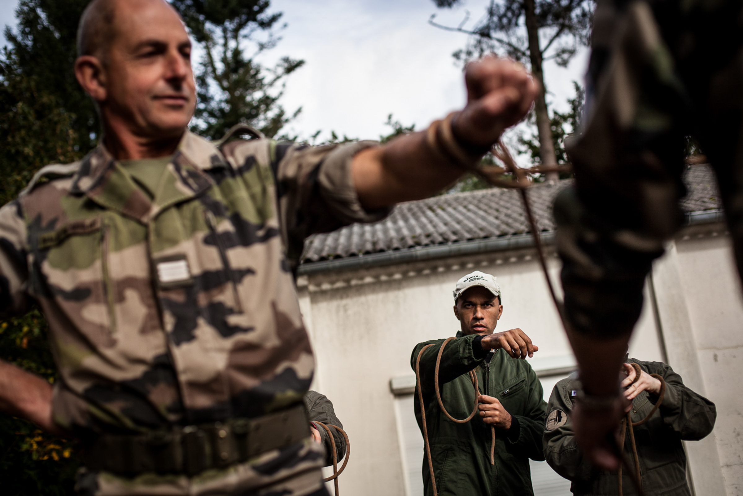 Coëtquidan, le 17 Octobre 2013. En fin de journée, Jean et les cadres de Veolia venus suivre un stage de leadership à l'école de Saint Cyr apprennent à faire les noeuds qui leur serviront à la construction d'un pont.

Coëtquidan, 17 October 2013. By late afternoon, John and executives from Veolia following a leadership course at the School of Saint Cyr learn how to make nodes that will serve them to build a bridge.